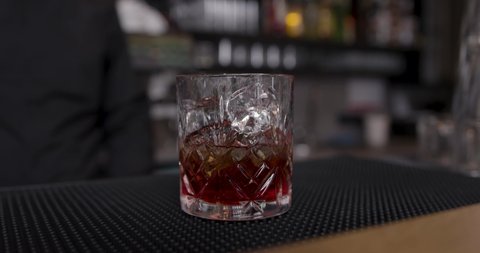 Barkeeper stirring cocktail - red drink