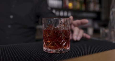 Barkeeper adding orange to cocktail
