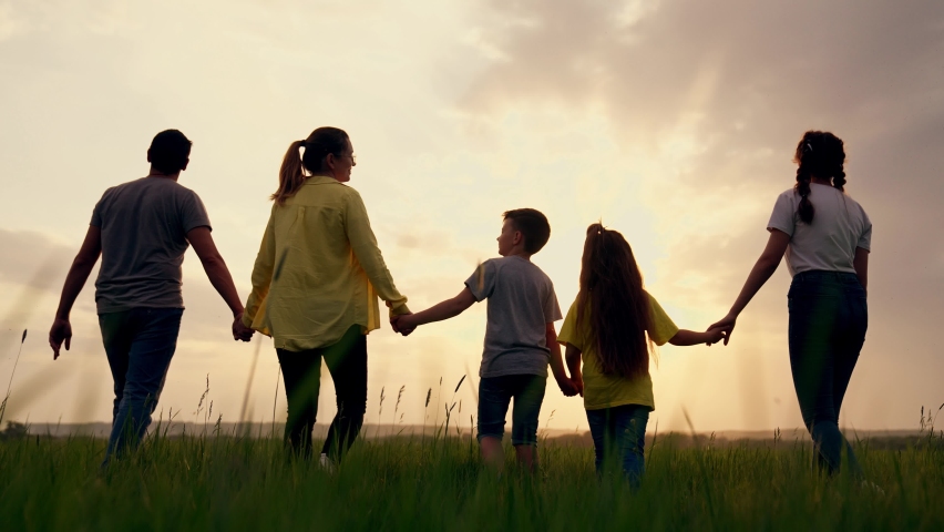 Big happy family. Summer people in park at sunset. Family is walk on green grass in natural park. Family fun, joy in nature. Healthy young family at sunset. Concept of happy people in nature in grass Royalty-Free Stock Footage #1087544531
