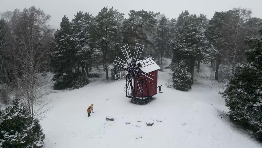 Sweden old windmill covered with snow with people