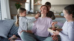 Three litttle children doing massage and apllying make up to their mother at home. - Powered by Shutterstock - Get 15% off with code: PIKWIZARD15