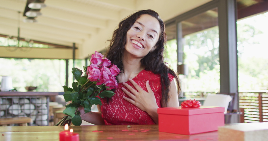 Happy biracial woman with roses making valentine