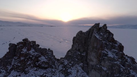 Aerial shot of Shamanka rock on an Olkhon Island. Beautiful view on frozen Baikal. Panoramic winter landscape. Popular touristic destination