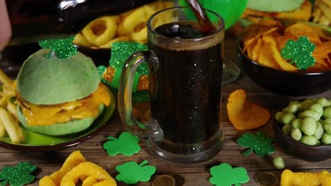 St Patrick`s holiday party invitation, bar menu background. Irish St Patrick`s day beer, ale glasses, snacks, appetizer, green burger, wooden bar table with shamrock, clover, coins, leprechaun hat 