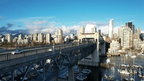 Aerial Footage Over The Burrard Bridge in Downtown Vancouver Marina, With Seagulls Moving Towards the Camera. The Cityscape Skyscrapers of the British Columbia, Canada.