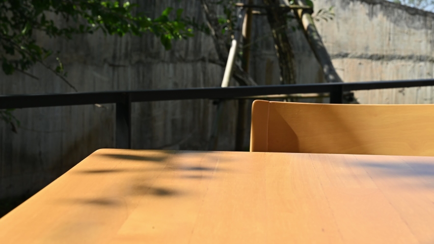 Waitress serving Matcha (or green tea) croissant with plate on wooden table. Croissant is a French buttery, flaky and crescent-shaped bread.