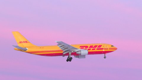Oslo Airport Norway - February 22 2022: dhl cargo airplane airbus a300 side view panning right passing pantone very pery morning