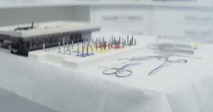 The table of a dentist with dental instruments laid out on it, a syringe with anesthesia, scissors and nozzles for a drill machine, prepared for work, close-up. Video in 4k, red komodo