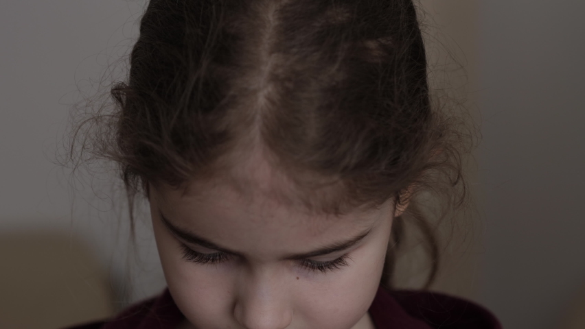 Portrait Sad Little Child Girl Looking at Camera. Thinking Curiosity Child Looking at Camera Closeup Indoors. Depressed Face Eyes Serious Contemplative Child. Serious Student Having Problems at School Royalty-Free Stock Footage #1087564580