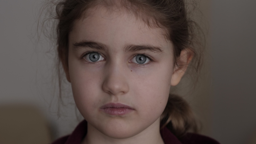 Portrait Sad Little Child Girl Looking at Camera. Thinking Curiosity Child Looking at Camera Closeup Indoors. Depressed Face Eyes Serious Contemplative Child. Serious Student Having Problems at School | Shutterstock HD Video #1087564580