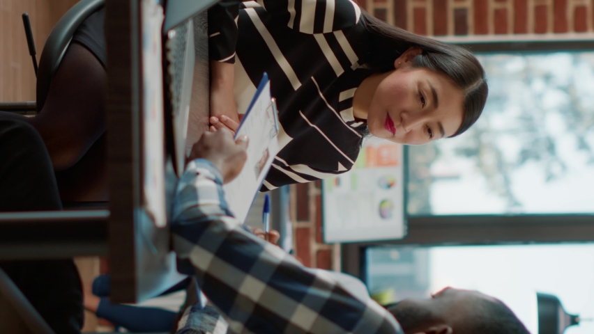 Vertical video: Male recruiter interviewing job seeker about work experience, making employment offer. Man and woman meeting to discuss about HR recruitment, analyzing resume information to hire.