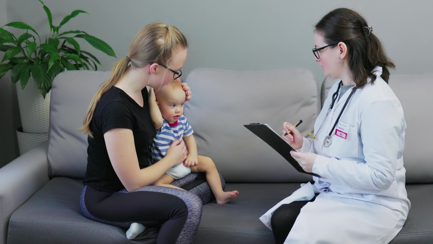 doctor woman visiting baby toddler at home, appointment mother and child home, doctor examines kids neck, ears, stomach, doing check-up stethoscope. mother holds son knees, sitting on sofa living room Royalty-Free Stock Footage #1087568435