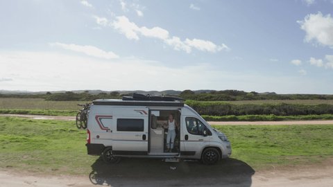 Van life, drone shot of camper van parked on the beach, adventure travel concept 