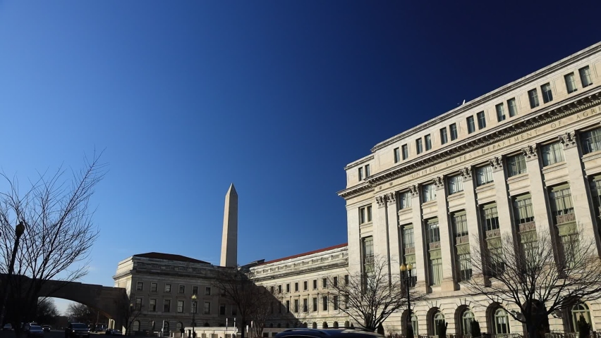 Panning shot of USDA headquarters, the U.S. Department of Agriculture Jamie L. Whitten Building in Washington, D.C. The camera pans from the Washington monument to the south-facing facade.