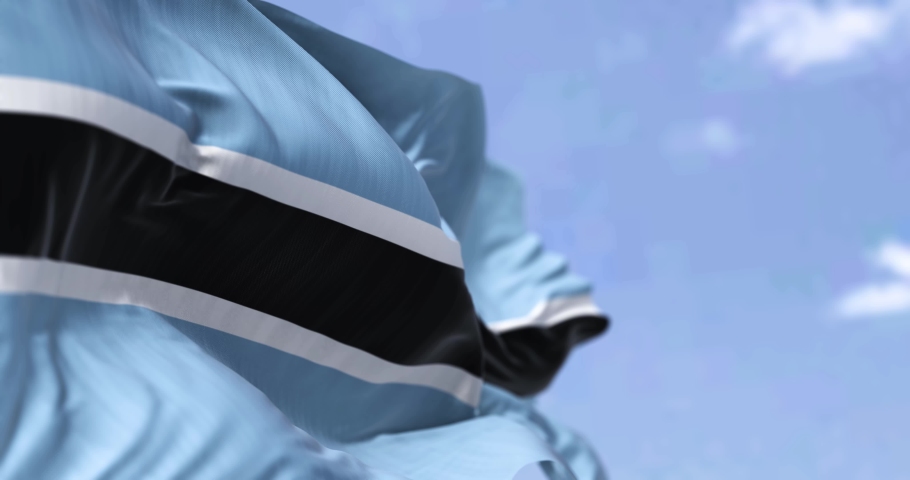 Detail of the national flag of Botswana waving in the wind on a clear day. Democracy and politics. Selective focus. Botswana is a landlocked country in Southern Africa. Seamless slow motion Royalty-Free Stock Footage #1087579025