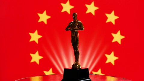 Hollywood Golden Oscar Academy award statue on red background with yellow stars around. Success and victory concept. Rotation