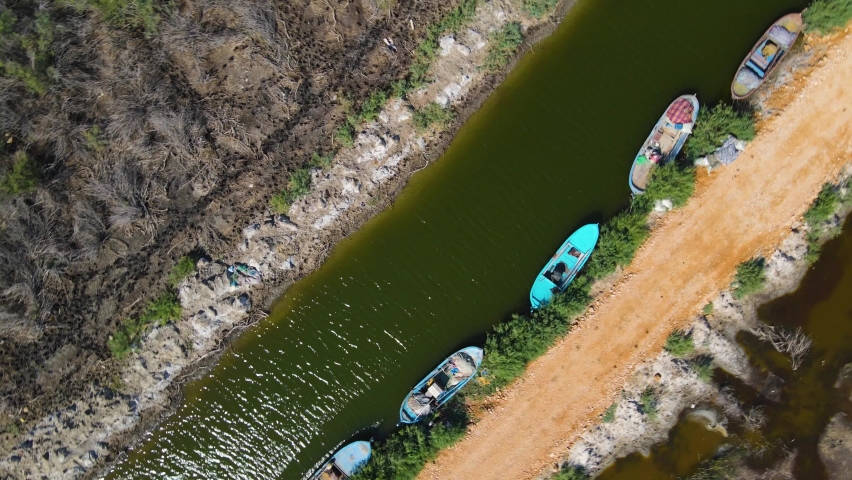 Natural Lake for holiday. Drone shot over. Summer landscape with mountains, forest and lake. Aerial View. Village by the lake. Mountain lake with turquoise water and green trees.