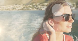 Animation of bokeh over caucasian teenager girl wearing glasses and sailing. holidays, vacations and leisure time concept digitally generated video.