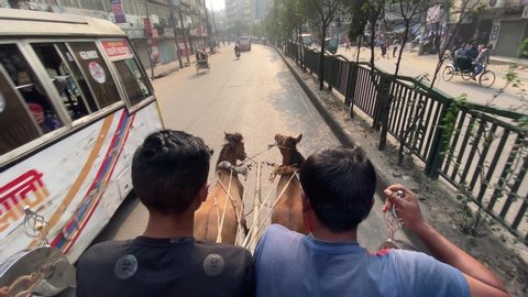Dhaka , Bangladesh - 02 03 2022: Two horse are pulling a horse drawn carriage on Dhaka city road