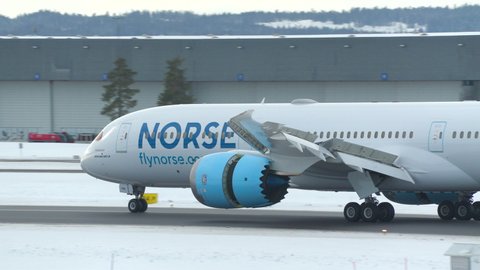 Oslo Airport Norway - February 23 2022: airplane boeing 787 dreamliner norse atlantic airlines arrival landing rear view winter light 