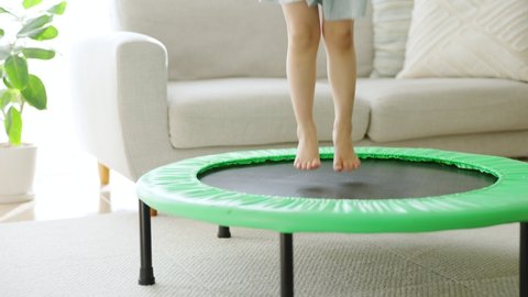 Asian child jumping on a trampoline.