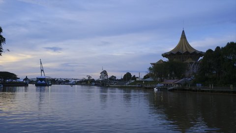  Kuching, Malaysia- Circa February, 2022: A low light timelapse footage with noise effect of beautiful Sarawak State Assembly building and colourful light during dusk. 