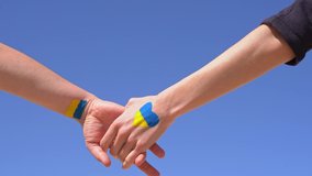 female hands painted in Ukraine flag colors yellow-blue holding. Stop the war and the power of Ukraine, patriotism and Kiev, strength and power - Powered by Shutterstock - Get 15% off with code: PIKWIZARD15