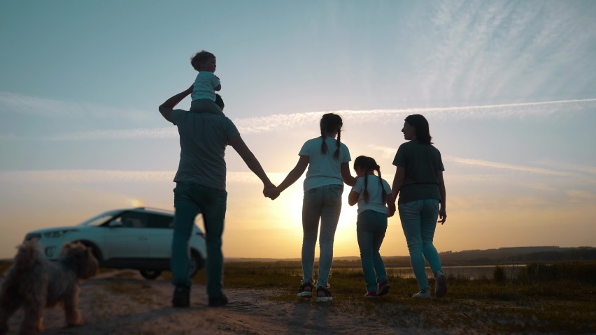 people in the park. happy family a silhouette walk at sunset. car travel kid dream concept. happy family parents and fun children sun walk silhouette next to car. family walk next to car Royalty-Free Stock Footage #1087621397