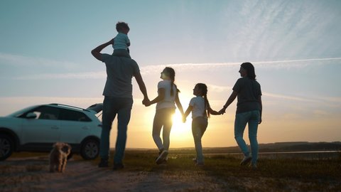 people in the park. happy family a silhouette walk at sunset. car travel kid dream concept. happy family parents and fun children sun walk silhouette next to car. family walk next to car
