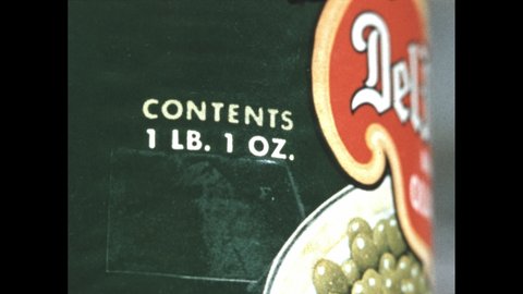 1950s: Weight of contents is written on canned peas label. Dump truck parks at truck weighing station.