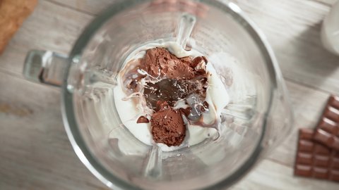 Chocolate Ice Cream Milkshake Mixed in High-Speed Blender in Slow Motion - Top View, Camera Moves Out