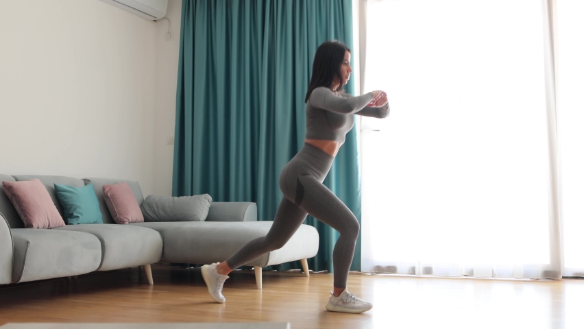 female butt workout squats at home. Athletic Woman squats workout in living room. Female gymnastics. Glutes workout motivation. Fitness at home concept. Royalty-Free Stock Footage #1087635017