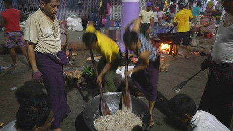 YANGON, MYANMAR - 18TH FEBRUARY, 2019: Local men cook food in the street of the Yangon, Myanmar, Asia