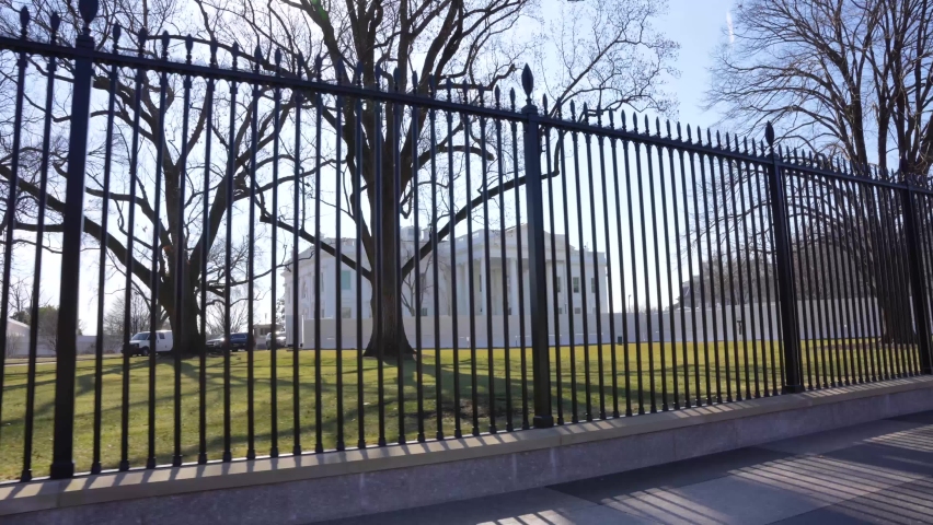 A glide shot from behind the gates of the White House on a nice sunny day.