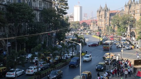 Mumbai, Maharashtra, India - 31 Jan 2022: Real time clip of vehicle traffic on the road leading to Chhatrapati Shivaji Terminus (CST) Railway station building. Vehicle traffic outside UNESCO heritage.