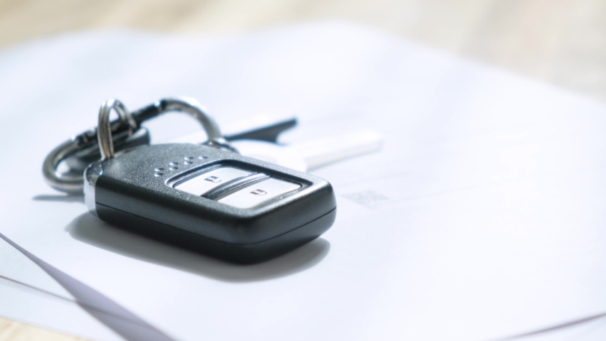 Man signs documents with focus on cars key