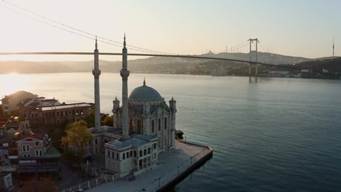 Stunning long aerial shot of Ortakoy Mosque with a scenery of Bosphorus Bridge