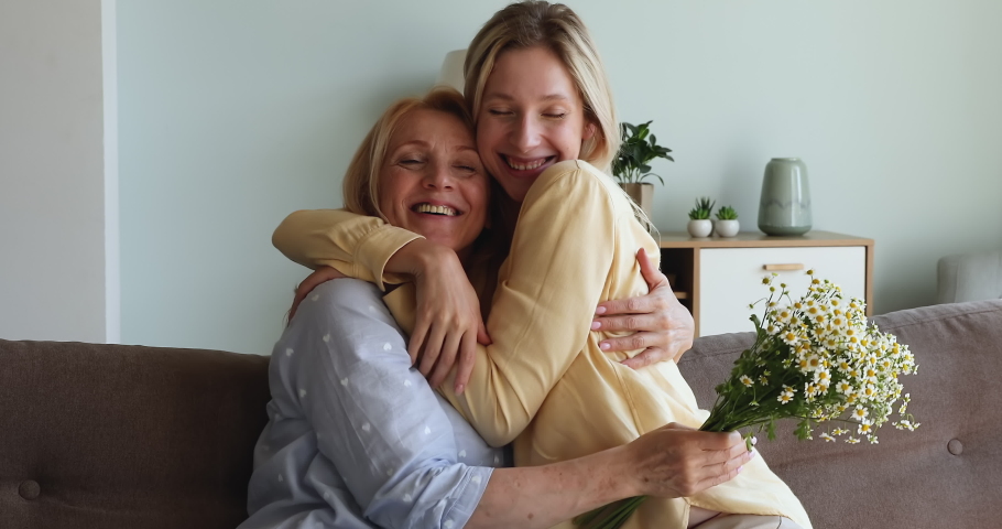 International Womens Day, Happy Mother Day celebration concept. Beautiful young adult daughter congratulates her older cheerful mom on birthday, make surprise hugging express love giving spring flower Royalty-Free Stock Footage #1087646039