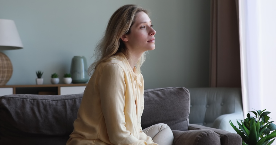 Thoughtful young 25s blond woman sit on sofa, reflecting, looks upset deep in thoughts suffers from unrequited love, having melancholy mood, experiences life troubles, break up of relationship concept | Shutterstock HD Video #1087646162