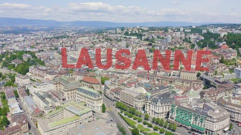 Inscription on video. Lausanne, Switzerland. Flight over the central part of the city. La Cite is a district historical centre. On the mechanical display, Aerial View, Departure of the camera