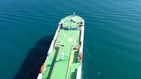 Perama, Attica| Greece - February 25 2022: Aerial drone video of huge car carrier ship RO-RO (Roll on Roll off) leaving automobile terminal of Keratsini