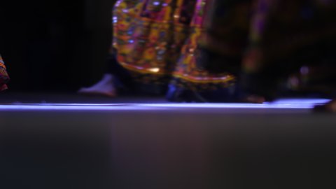 A group of girls dance a cultural dance of India. Close-up of women's feet in Indian outfits.