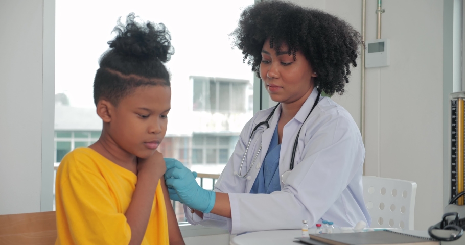 African-American children getting vaccine in clinic or hospital, with hand nurse injecting vaccine to get immunity for protection. vaccine for kids concept. Royalty-Free Stock Footage #1087654436