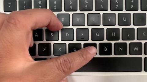 Male hand initiates a keyboard key press sequence, command x cut and paste buttons to move files digitally on laptops desktop folder on system hard drive