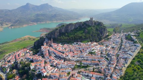 aerial view of picturesque Spanish white village near a lake,  historic town in Andalusia, Spain, flying around a famous Andalusian tourist destination 