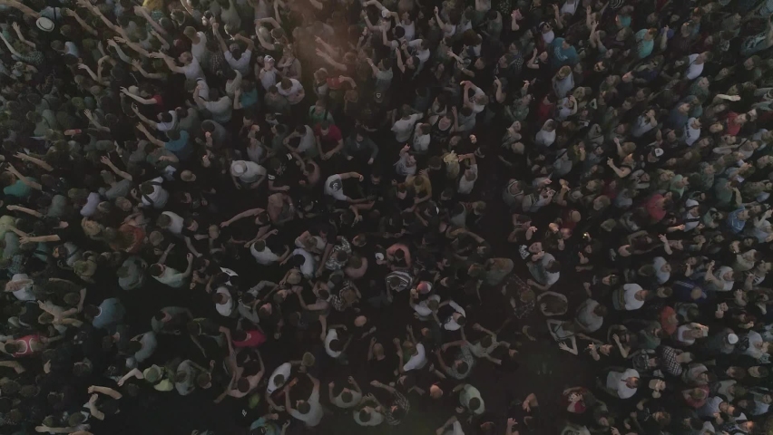 Crowd of people at a concert in the evening, Aerial view of a huge concert crowd having fun with popular electronic music at an open air festival at night. View from drone Royalty-Free Stock Footage #1087664939