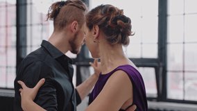 Close shot of couple dancing tango in grey studio against large windows. People face to face dancing romantic dance. Slow motion dancing tango. High quality 4k footage - Powered by Shutterstock - Get 15% off with code: PIKWIZARD15
