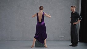 Man teaching woman dancing tango in grey studio against large windows. People practicing dancing romantic dance. Slow motion dancing tango. High quality 4k footage - Powered by Shutterstock - Get 15% off with code: PIKWIZARD15