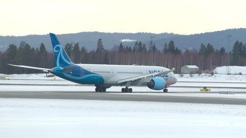 Oslo Airport Norway - February 23 2022: airplane boeing 787 dreamliner norse atlantic airlines arrival retract spoilers rear view winter light