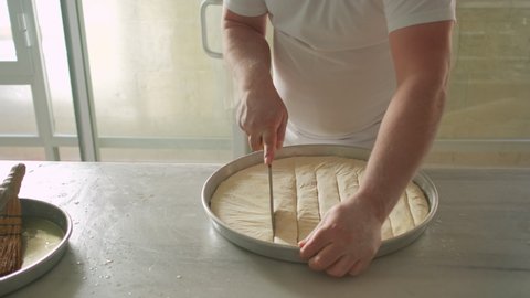 Process of cooking traditional turkish baklava pastry. Unidentified chef cutting thin filo dough for turkish pistachio dessert baklava